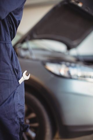 Section médiane d'un mécanicien avec un outil clé dans la poche du garage